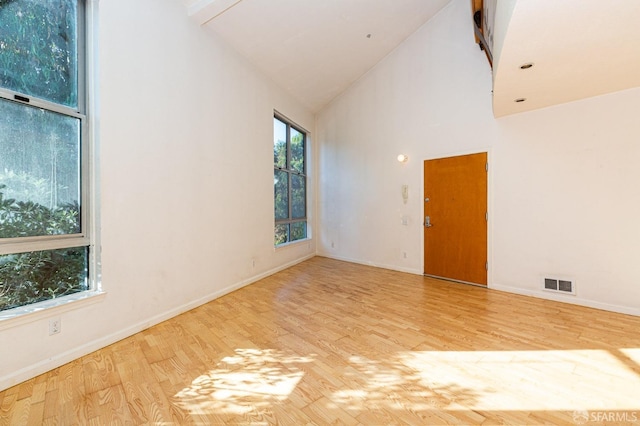 unfurnished room featuring light hardwood / wood-style flooring and high vaulted ceiling