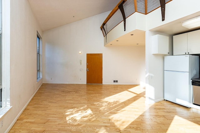 kitchen featuring white fridge, high vaulted ceiling, white cabinetry, and light hardwood / wood-style flooring