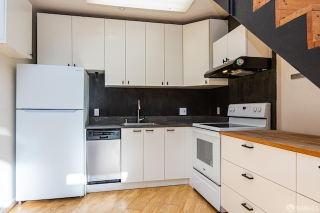 kitchen featuring white cabinetry, sink, white appliances, decorative backsplash, and light wood-type flooring