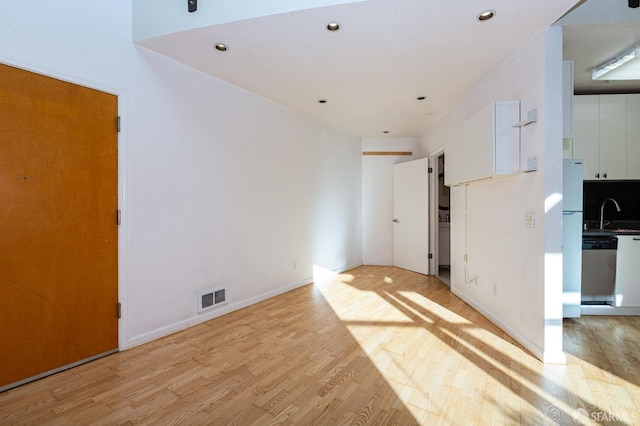 empty room featuring sink and light wood-type flooring