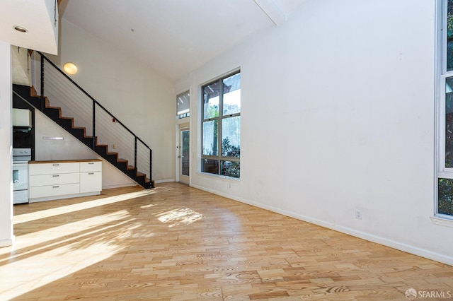 unfurnished living room with light hardwood / wood-style floors and lofted ceiling