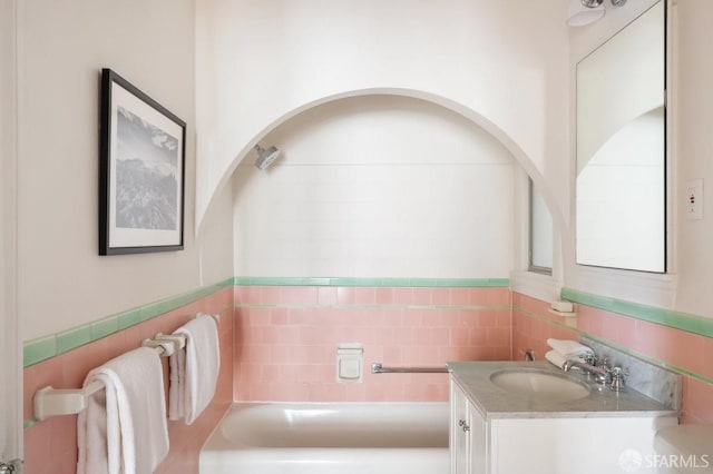 full bath with tile walls, vanity, and wainscoting