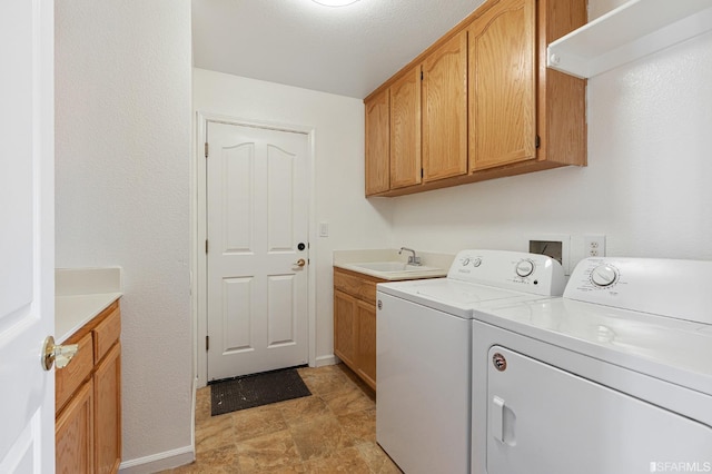 laundry area with sink, washer and clothes dryer, and cabinets