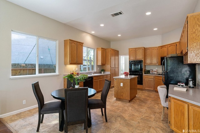 kitchen featuring a center island, built in desk, decorative backsplash, and black appliances