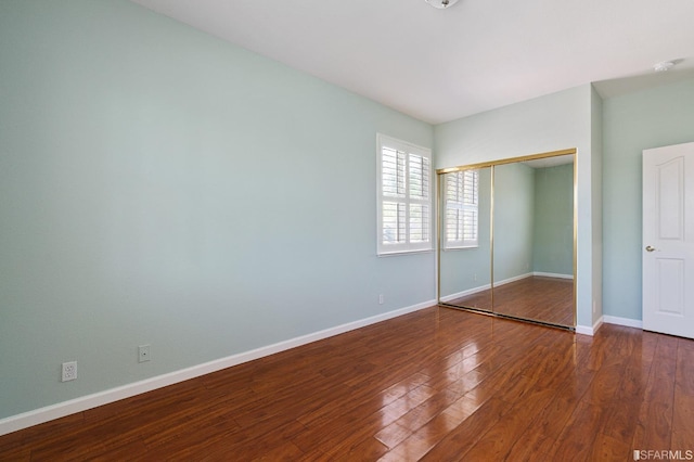 unfurnished bedroom with hardwood / wood-style flooring and a closet