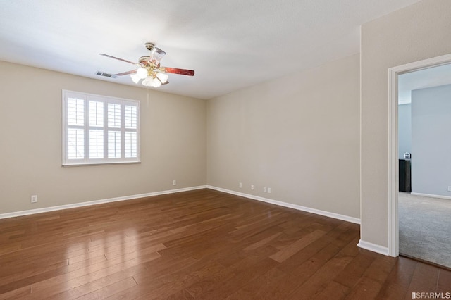 empty room with dark wood-type flooring and ceiling fan