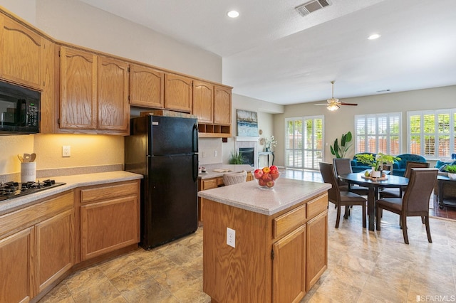 kitchen with ceiling fan, a center island, and black appliances