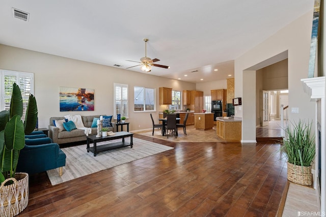 living room with ceiling fan and light hardwood / wood-style flooring