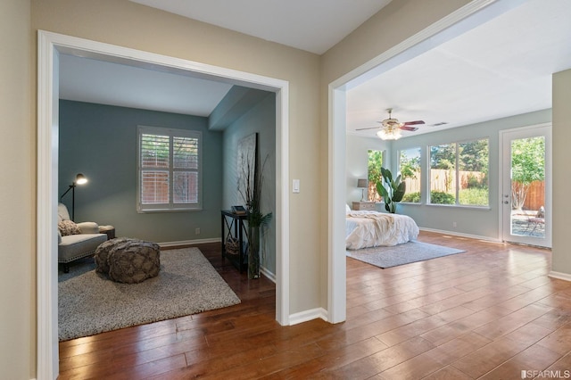 bedroom with access to exterior, hardwood / wood-style floors, and ceiling fan