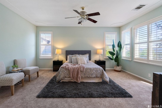 carpeted bedroom with ceiling fan and multiple windows