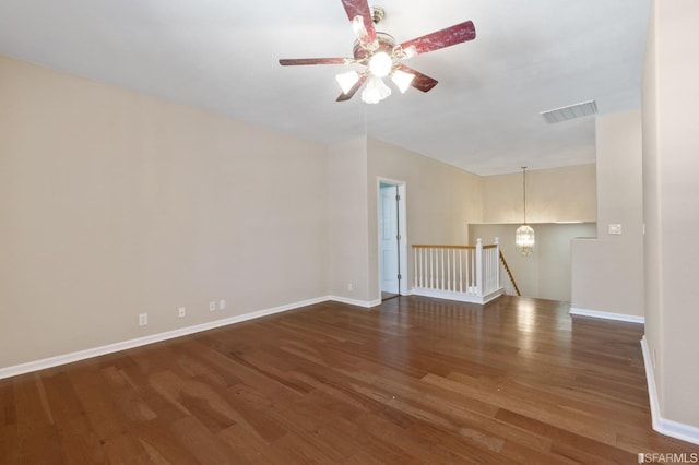 unfurnished living room with dark wood-type flooring and ceiling fan with notable chandelier