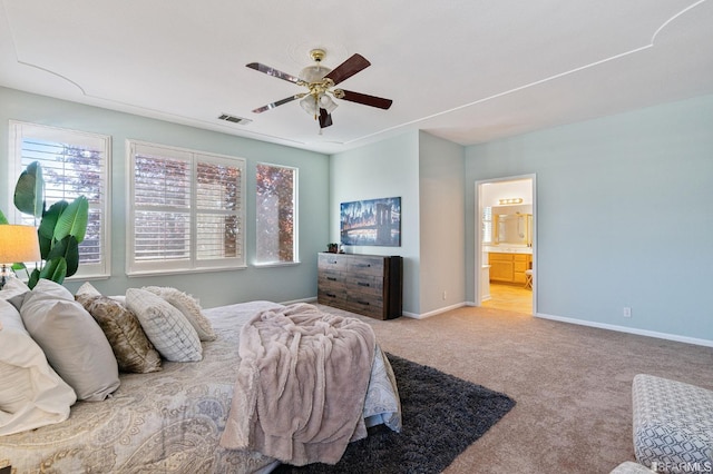 bedroom featuring ceiling fan, ensuite bath, and light carpet