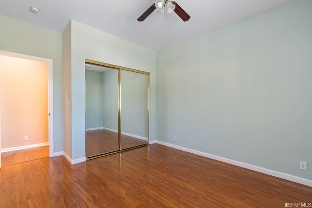 unfurnished bedroom with ceiling fan, wood-type flooring, and a closet