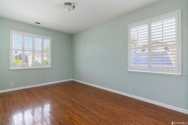 spare room with dark hardwood / wood-style floors