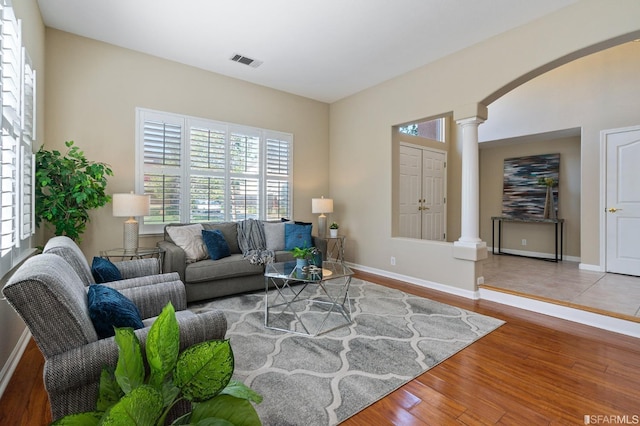 living room with hardwood / wood-style flooring and ornate columns