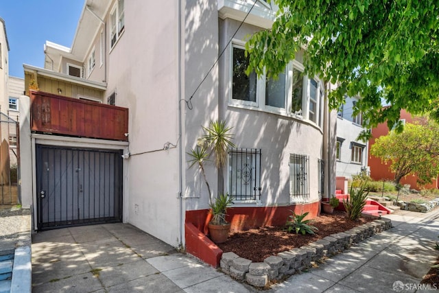488 41st St, Oakland, CA 94609 - view of side of home featuring stucco siding and a garage