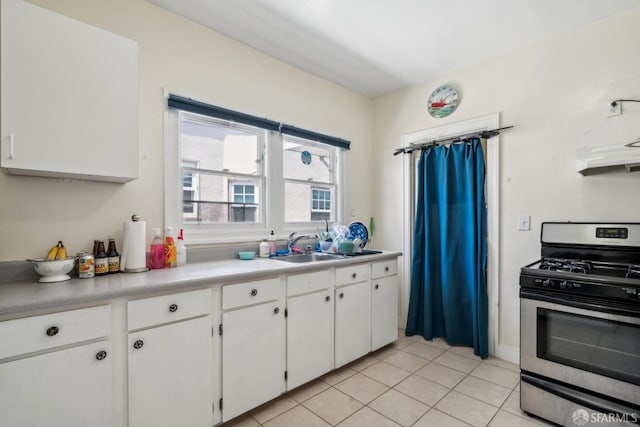 488 41st St, Oakland, CA 94609 - kitchen featuring stainless steel gas range, light tile patterned floors, white cabinets, under cabinet range hood, and a sink
