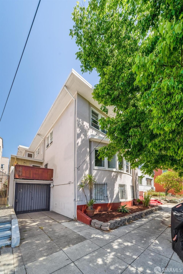 488 41st St, Oakland, CA 94609 - view of front of property featuring stucco siding, concrete driveway, and a garage