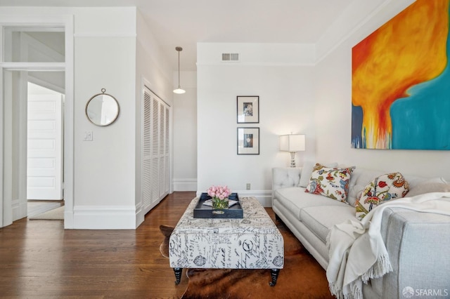 living area featuring wood finished floors, visible vents, and baseboards