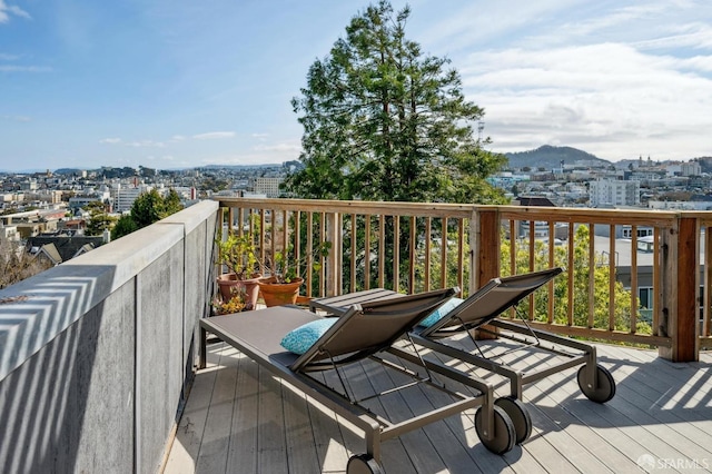 wooden terrace featuring a city view and a mountain view