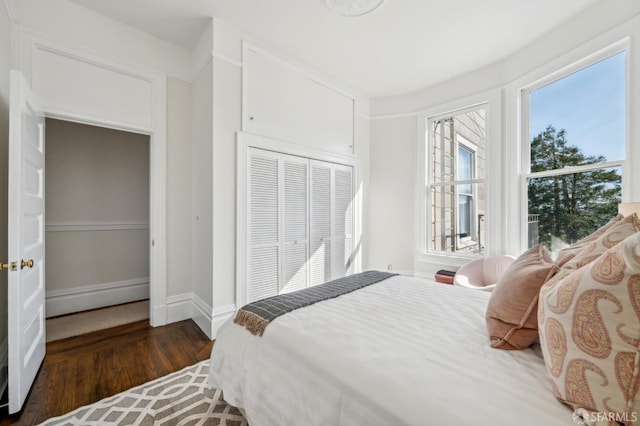 bedroom featuring a closet, baseboards, and wood finished floors