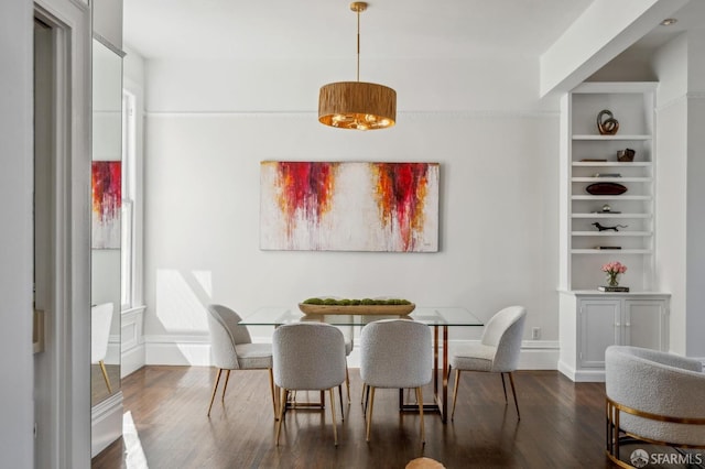 dining space with built in shelves, baseboards, and wood finished floors