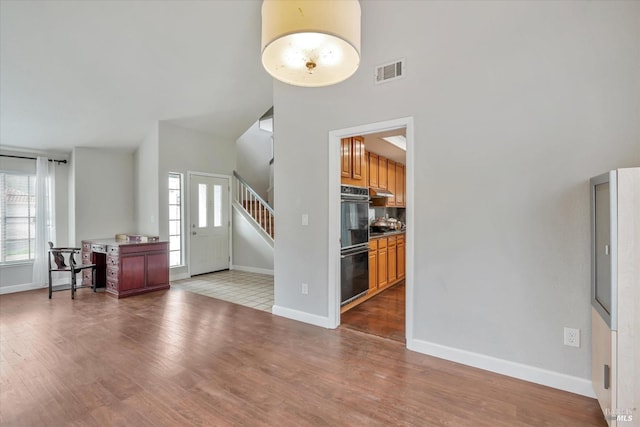 foyer with a towering ceiling and hardwood / wood-style floors