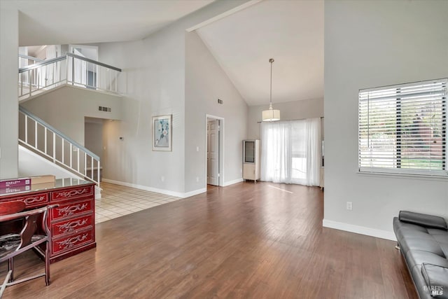 living room featuring high vaulted ceiling and wood-type flooring