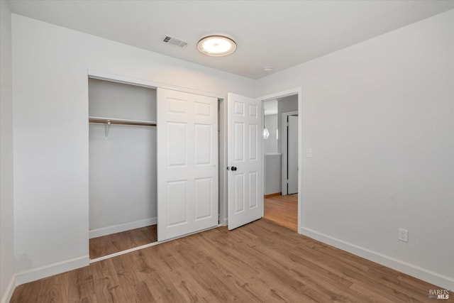 unfurnished bedroom featuring a closet and light hardwood / wood-style flooring