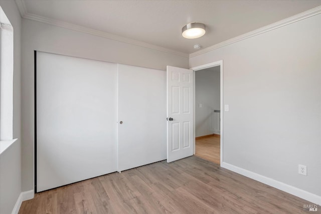 unfurnished bedroom featuring a closet, light wood-type flooring, and ornamental molding