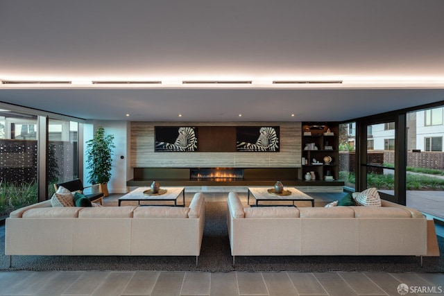 living room featuring a large fireplace and floor to ceiling windows