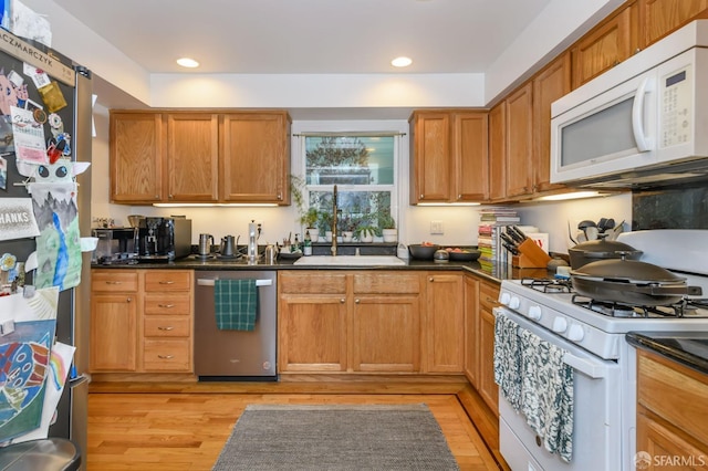 kitchen with light wood-type flooring, stainless steel appliances, and sink