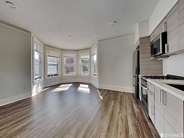 kitchen featuring wood-type flooring, crown molding, and stainless steel appliances