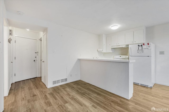 kitchen with light hardwood / wood-style floors, stove, white fridge, white cabinets, and kitchen peninsula