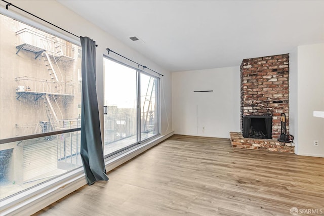 unfurnished living room with hardwood / wood-style floors and a fireplace