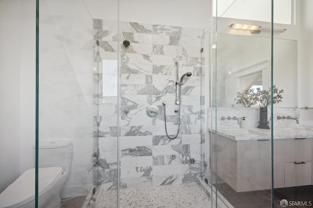 bathroom with toilet, a shower with shower door, and vanity