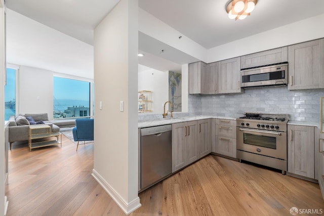 401 Harrison St Unit 23C, San Francisco, CA 94105 - kitchen with stainless steel appliances, gray cabinets, light wood-style flooring, backsplash, and open floor plan