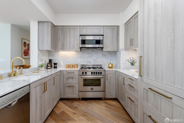 401 Harrison St Unit 23C, San Francisco, CA 94105 - kitchen with stainless steel appliances, gray cabinetry, light stone counters, and light wood-type flooring