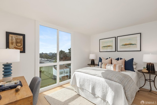 bedroom featuring wood finished floors and an office area