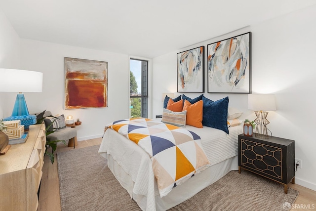 bedroom featuring wood finished floors and baseboards