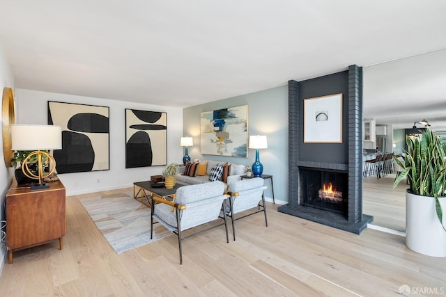 living room with wood finished floors, a fireplace, and baseboards