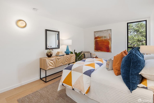 bedroom with wood finished floors and baseboards