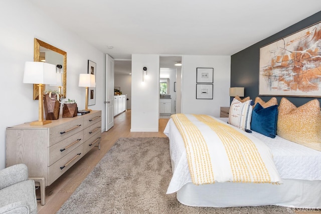 bedroom featuring light wood-type flooring and ensuite bathroom