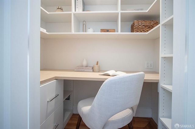 office space with dark wood finished floors and built in desk