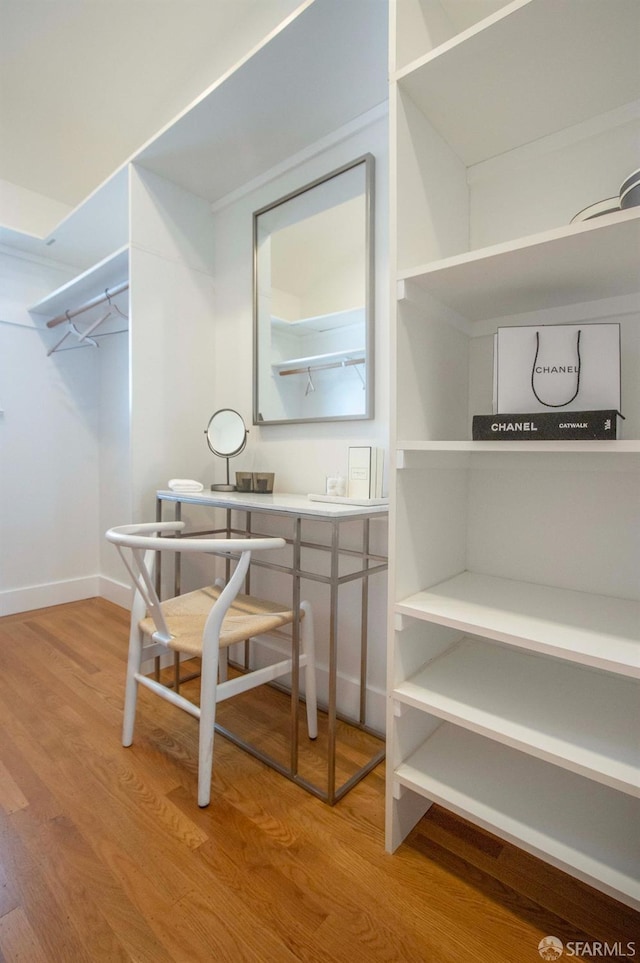 walk in closet with wood finished floors