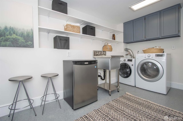 laundry room featuring cabinet space, independent washer and dryer, baseboards, and a sink