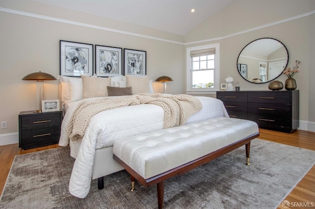 bedroom featuring vaulted ceiling, crown molding, wood finished floors, and baseboards