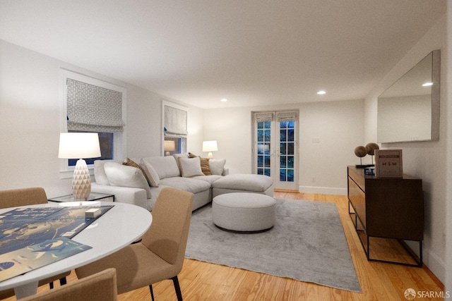 living area featuring recessed lighting, french doors, baseboards, and light wood finished floors