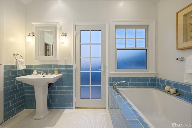 full bathroom with tile patterned flooring, a wainscoted wall, tile walls, and a garden tub