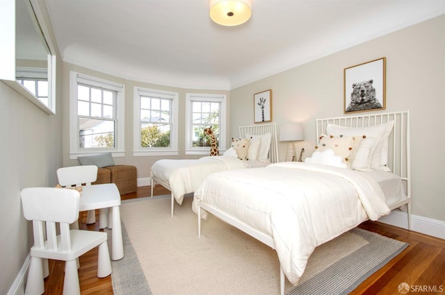 bedroom with baseboards and wood finished floors